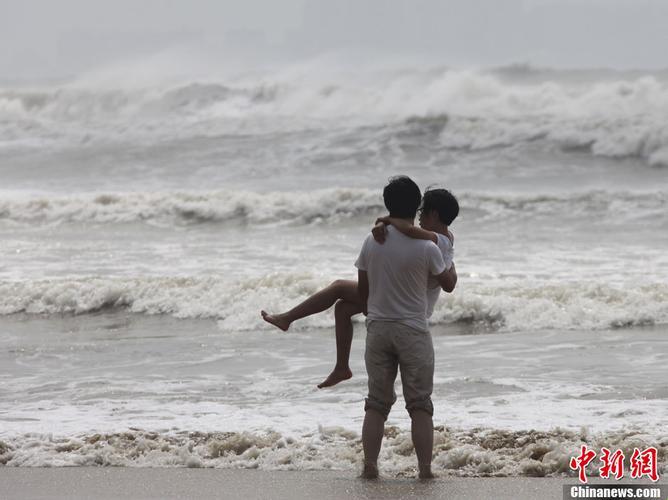 海浪里的潮流秀：情侣拥吻，潮起险情